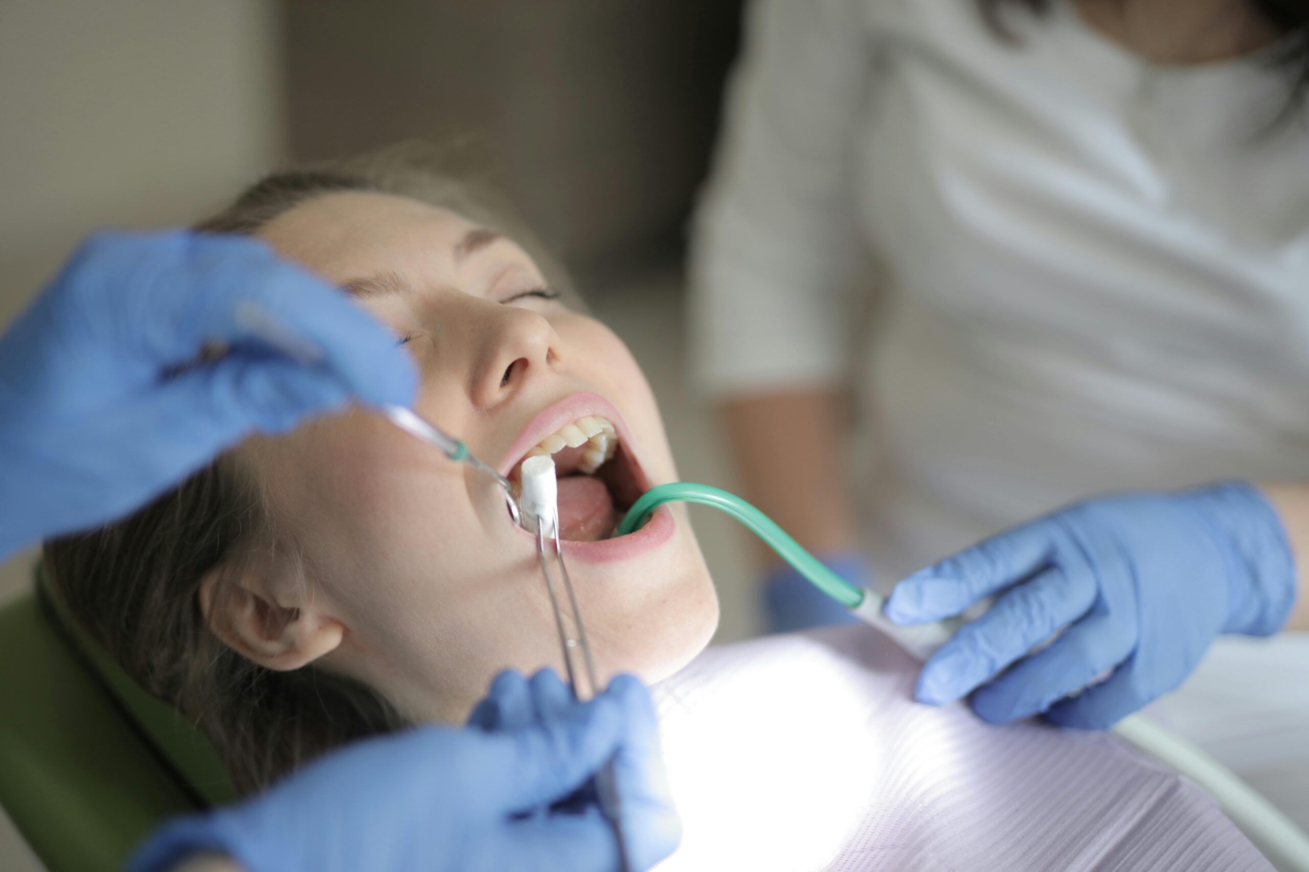 Markham Dentist examines a patient using tools in a clinical setting.
